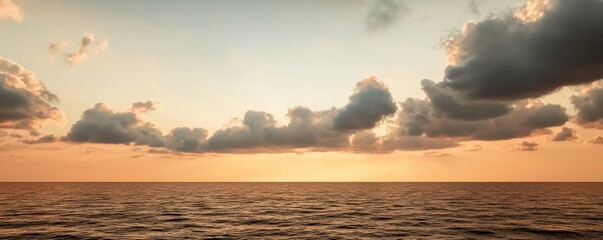 Naklejka premium A tranquil sunset over the ocean, with soft clouds and a serene reflection on the water surface, perfect for relaxation.