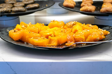 Roasted pumpkin slices in sugar syrup, sweet dessert, close-up