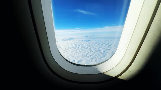 Passenger pov on flight from plane window with a blue sky and clouds