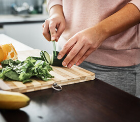 Cooking, vegetables and hands of person in kitchen for meal prep for dinner, supper and lunch in home. Recipe, diet and closeup of cucumber on counter for wellness, nutrition and healthy eating
