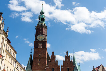 Old town hall tower under a cloudy blue sky on a sunny summer day. Concept of historical...