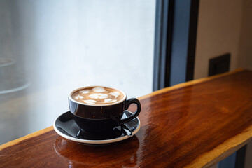 Hot coffee latte with latte art milk foam in cup mug on wood desk on top view. As breakfast In a coffee shop at the cafe,during business work concept,vintage style
