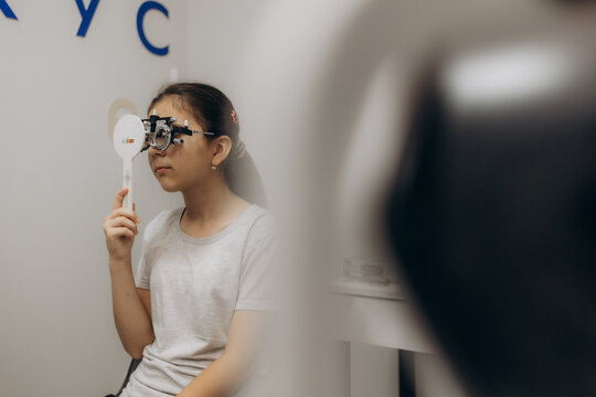 Optometrist examines the sight of young girl