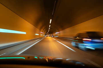 Blurred cars in an illuminated underground tunnel. Slow shutter speed, cars in traffic, no people