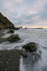 Cloudy sunset view over rocky coastline.