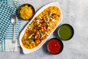 Dabeli is a spicy Indian street food made with a potato filling, tamarind chutney, and sev, served in a bun.