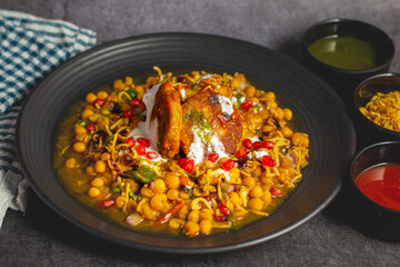 Dabeli is a spicy Indian street food made with a potato filling, tamarind chutney, and sev, served in a bun.