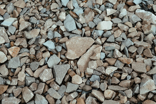 A close-up view of assorted gravel and crushed stones on a construction site, showcasing various sizes and textures during daylight