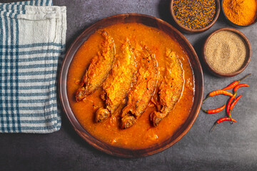 A rich, spicy Bengali dish featuring soft pabda fish simmered in a flavorful mustard-tomato gravy.
