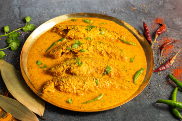 A rich, spicy Bengali dish featuring soft pabda fish simmered in a flavorful mustard-tomato gravy.