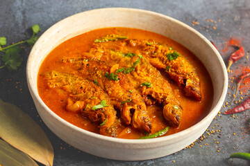 A rich, spicy Bengali dish featuring soft pabda fish simmered in a flavorful mustard-tomato gravy.