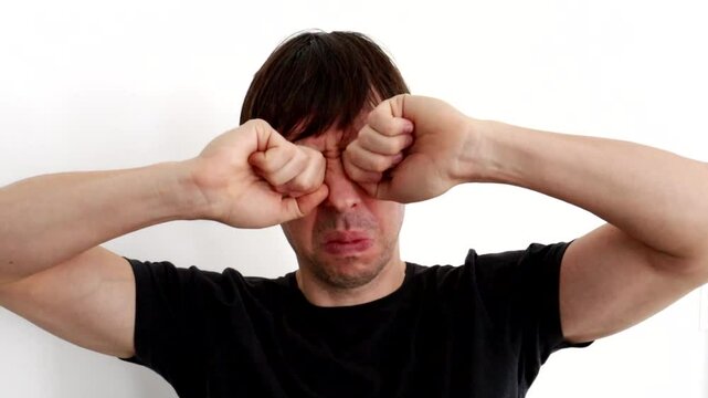 homem triste chorando com m&atilde;os no rosto 