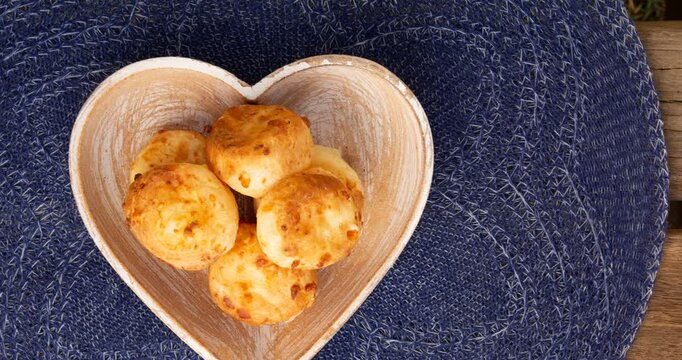 Minas Gerais cheese bread balls in a heart shapped bowl and clean background 

