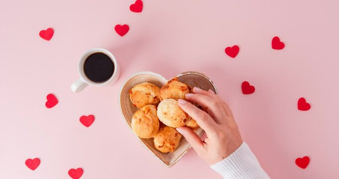 Minas Gerais cheese bread with picking hands and heart shaped and pink background aerial view