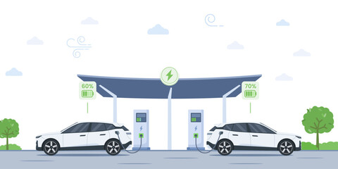 Two electric cars charge at a station under a solar-powered canopy with a city skyline silhouette. Battery EV vehicles are plugged in and get electricity from the charging module.