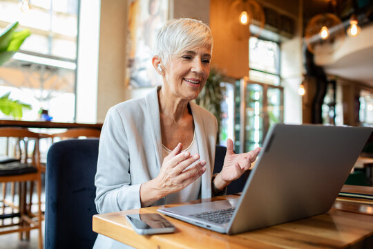 Senior businesswoman having video call on laptop in cafe