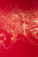 Curls of smoke on a red background