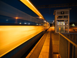 French speeding train passing through empty platform at night