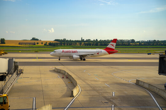 Vienna, Austria - June 26, 2024 : Austrian Airlines Airbus A320 taxiing at Vienna International Airport with open fields in the background.