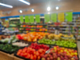 Defocused blurred image of supermarket store shelves with fruits and vegetables background.