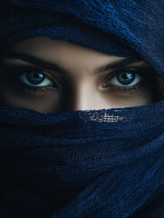 Naklejka premium A woman with blue eyes is wearing a blue scarf over her face