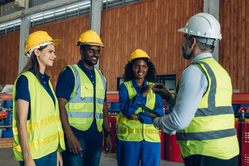 The Manager are taking a safety briefing before work. Implementation of safety culture at Factory. Factory Meeting:  Chief Engineer Talking to Colleagues Before Work Day in Heavy Industry