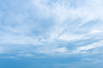 Fototapeta premium Fluffy white clouds drift across a vibrant blue sky, creating a breathtaking natural masterpiece