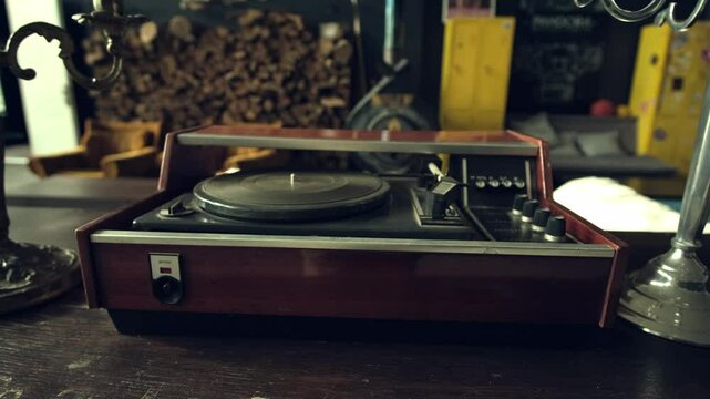 Close-up of an old vintage turntable with a dust-covered record player in a retro room setting.
