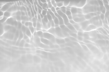 White water with ripples on the surface. Defocus blurred transparent white colored clear calm water surface texture with splashes and bubbles. Water waves with shining pattern texture background.