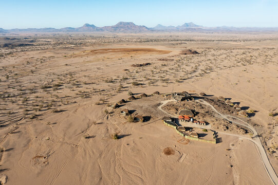 Aerial view of The Doro Nawas Camp and arid desert plains at the edge of the dry bed of the Aba-Huab river, at dawn, Damaraland, Kunene Region, Namibia.