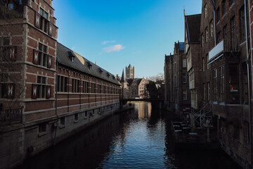Exploring the serene canals of Ghent, Belgium with historic architecture reflecting in the water during a tranquil afternoon