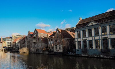 Charming canals and historic buildings grace the peaceful waters of Ghent, Belgium on a sunny day
