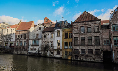 Charming old buildings along the canal in Ghent, Belgium with unique architecture on a bright day