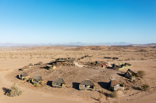 Aerial view of The Doro Nawas Camp and arid desert plains at the edge of the dry bed of the Aba-Huab river, at dawn, Damaraland, Kunene Region, Namibia.