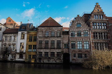 Exploring the historic architecture along the canals of Ghent, Belgium, under a clear blue sky in early spring