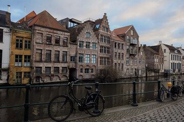 Exploring the picturesque canals and historic architecture of Ghent, Belgium at twilight with bicycles parked by the water