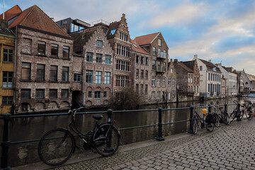 Fototapeta premium Exploring the charming canals and historic architecture along the banks in Ghent, Belgium during a tranquil afternoon stroll