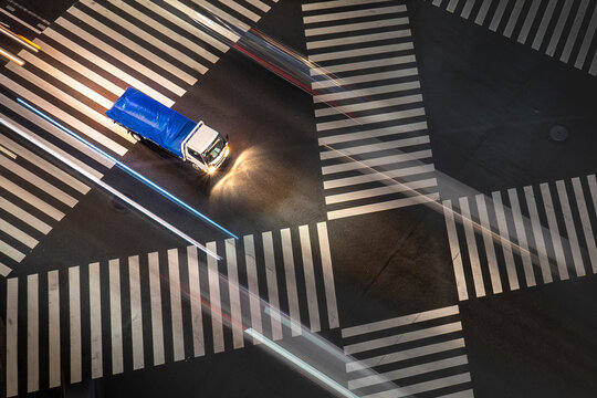 View of bustling traffic junction with light streaks and a speeding truck at night, Yurakucho, Tokyo, Japan.