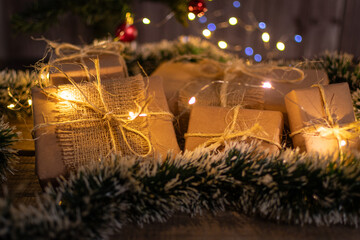 Group of wrapped Christmas gifts under the tree with Christmas lighting.