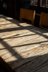 Natural light casting shadows across rustic wooden surface in a cozy indoor setting
