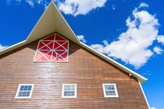 View of a picturesque wooden barn with a red facade under a clear blue sky, Cuauhtemoc, Mexico.