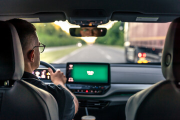 A male driver drives at speed through the streets of the city.