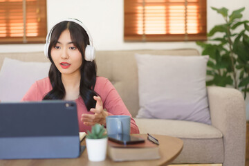 Young businesswoman in headphone explaining business data with partners while meeting in video call