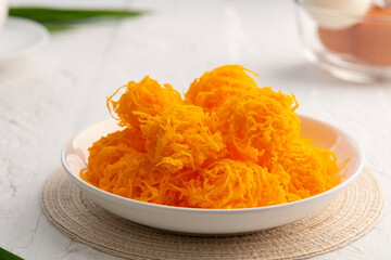 Close up Crispy Sweet egg floss or Golden Thread Egg,Shredded Egg Yolk Tart in white plate.