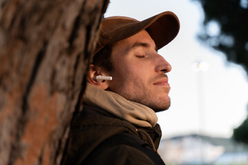 A relaxed man with his eyes closed listening to music with headphones