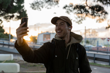 A man takes a selfie with his mobile while walking in the city