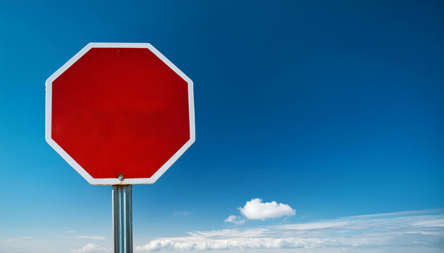 Blank stop sign against blue sky, sign on photo left with copy space on right