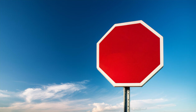 Blank stop sign against blue sky, sign on photo right with copy space on left 