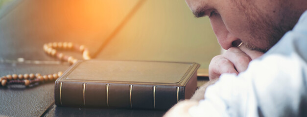 Pray and bible concept. Hand in hand together on bible by Caucasian man (worship christian),...