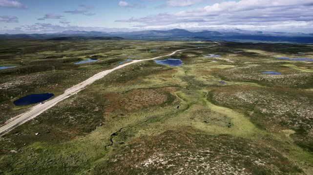 Aerial journey over Flatruet high fell, Flying over winding streams, waterholes, rural road and the vast moorland landscape, revealing stunning natural beauty in Sweden